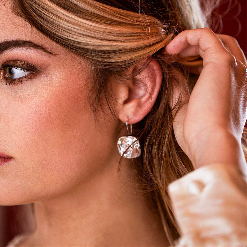 Woman adjusting her hair with a Crystal Premier Drop earring.