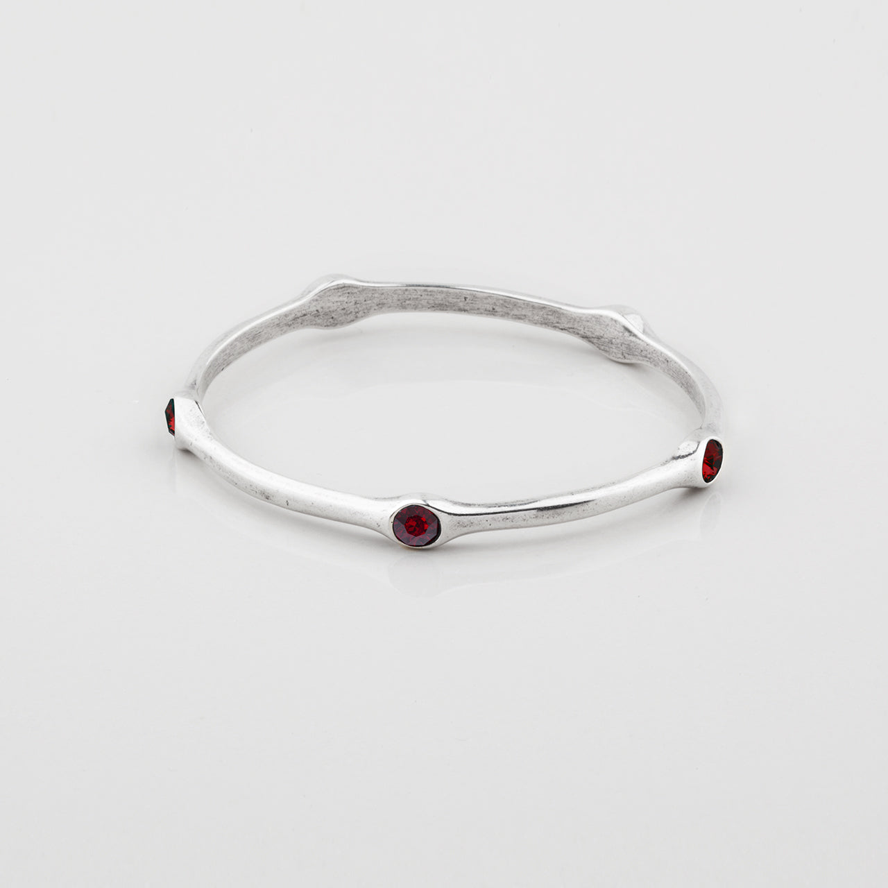Silver Miglio bangle with Ember Swarovski gemstones on a white background