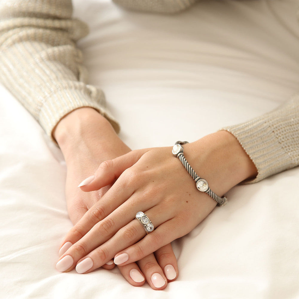 Close-up of hands wearing  a Miglio Luxe Twist Crystal Bracelet and a Sterling Silver Desire Trilogy Ring with AAA zirconia stones.