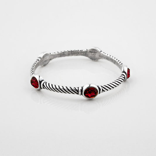 Silver bracelet with red gemstones on a white background