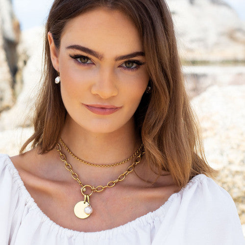 A model wearing a pair of 18ct gold-plated petite glamour rock earrings with lever back fastening and brilliant-cut Swarovski crystal inserts.