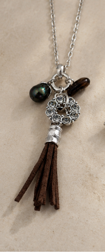 Necklace with tassel and pendant on a beige background