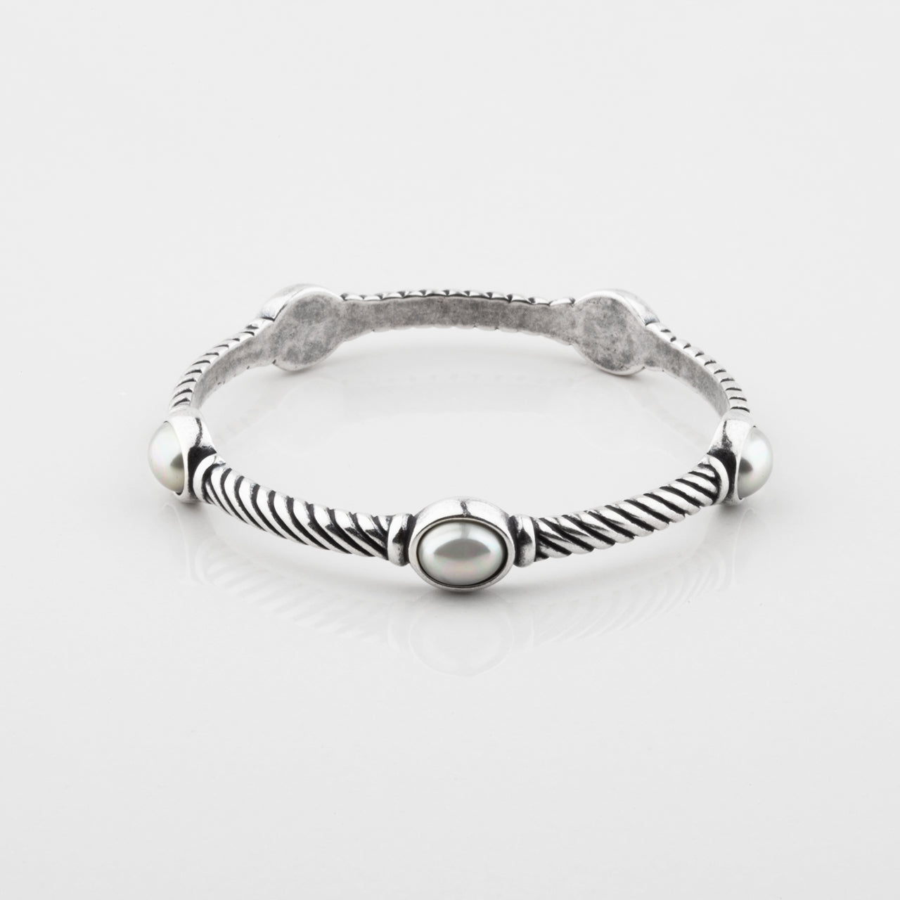 A burnished silver twist bangle bracelet with a five oval pearls, displayed on a clean white background.