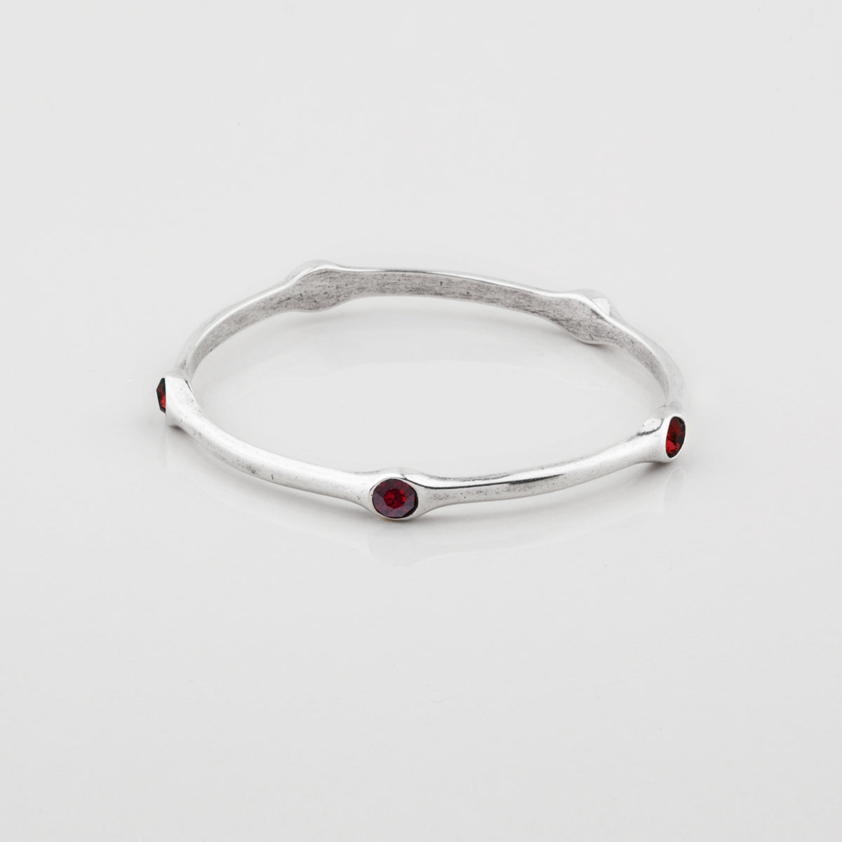 Silver Miglio bangle with Ember Swarovski gemstones on a white background