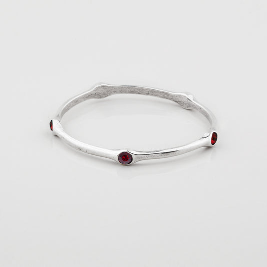 Silver Miglio bangle with Ember Swarovski gemstones on a white background