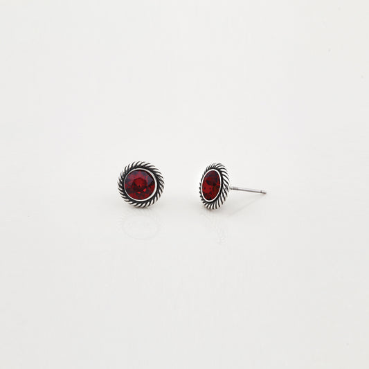Pair of silver earrings with red gemstones on a white background