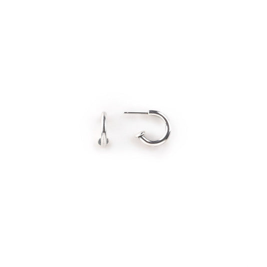 A pair of small, round, silver hoop earrings on a white background