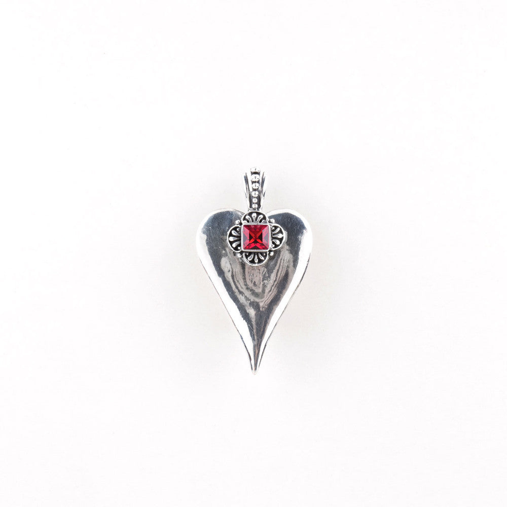 A silver plated heart-shaped pendant with a red Swarovski crystal embellishment at the top center, displayed against a white background.